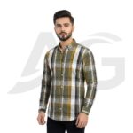 Front view of a man wearing a casual olive green, yellow, and white plaid long-sleeve button-down shirt.