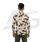 Back view of a man modeling a beige, brown, and black abstract print shirt with typography, showing the continuous graphic pattern and shoulder fit.