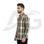 Left-facing side view of a man in an olive green, yellow, and white plaid casual shirt.