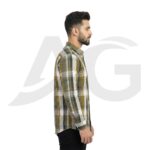 Right side profile of a man wearing an olive green and yellow plaid long-sleeve shirt with black jeans.