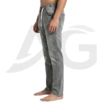 Right side profile of a man modeling casual grey drawstring pants with a fitted waist and relaxed leg.