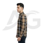 Left-facing side view of a man wearing a casual brown, black, and white plaid shirt