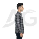Right side profile view of a man in a grey and black plaid long-sleeve shirt, showing the tailored sleeve and curved hemline.