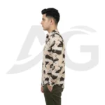 Left-facing side view of a man in a beige graphic print casual shirt with scattered letters and brushstrokes.