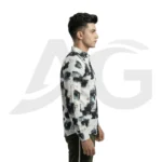 Left-facing side view of a man in a white graphic print casual shirt with scattered letters and black brushstrokes.