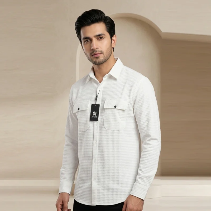 Male model wearing a crisp white textured long-sleeve button-down shirt featuring a grid pattern and dual chest pockets with contrasting dark buttons