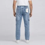 Back view of a male model wearing light blue acid wash denim cargo pants, showing an elastic waistband and classic rear patch pockets.
