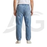 Back view of men's light blue baggy denim joggers showing a flexible elastic waistband and two standard rear patch pockets.
