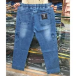 Back view of men's medium wash blue denim cargo pants highlighting back pockets, elastic waist, and garment-dyed finish.