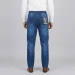 Light wash front-seam denim pants held up in a store setting, showing the elastic waist and vertical seam details.