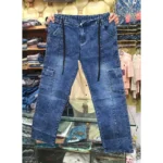Blue acid wash denim cargo pants held up in a retail store, clearly displaying the black drawstring, front vertical seams, and side cargo pockets.