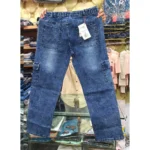 Back view of blue denim cargo pants held up in a retail setting, highlighting the gathered elastic waist, rear pockets with a size tag, and side cargo pockets.