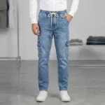 Male model wearing full-length regular fit blue denim cargo pants styled with a white shirt and white sneakers.