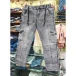 Grey acid wash denim cargo pants held up in a retail store, clearly displaying the black rope drawstring, front vertical seams, and side cargo pockets.