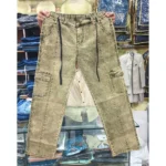 Khaki olive acid wash denim cargo pants held up in a retail store, clearly displaying the black drawstring, front vertical seams, and side cargo pockets.