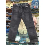 Back view of black denim drawstring pants held up in a retail setting, highlighting the gathered elastic waist and dual rear pockets.