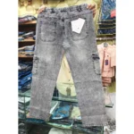 Back view of grey denim cargo pants held up in a retail setting, highlighting the gathered elastic waist, rear pockets with a size tag, and side cargo pockets.