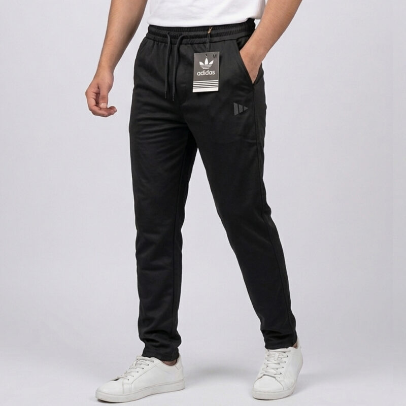 Men's black Adidas trousers in Pakistan featuring a slim fit design, elasticated drawstring waist, and subtle side branding.