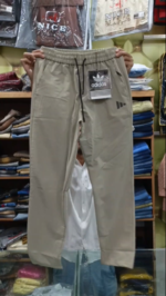 Men's beige Adidas cotton trousers in Pakistan featuring a slim fit, elastic drawstring waist, and black branding detail.