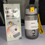 Grey frosted 720ml sports water bottle with pop-up straw lid and yellow strap